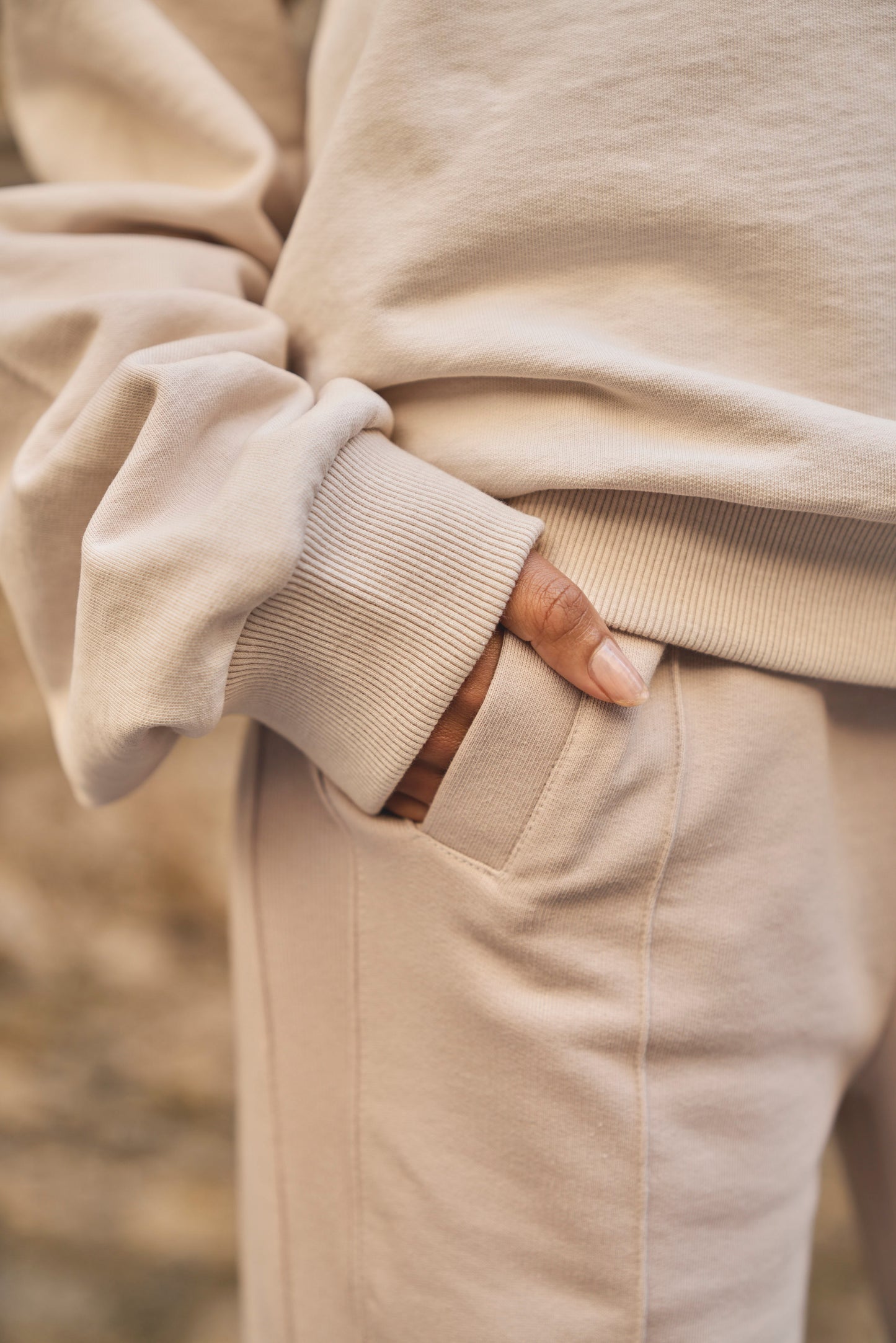 model with hand in pocket of luxury cream joggers