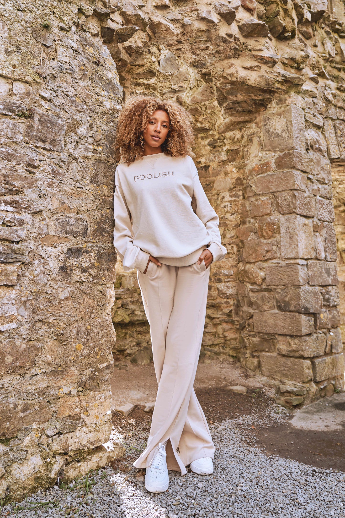 full length shot of model styled in matching luxury sweatshirt and joggers set in cream