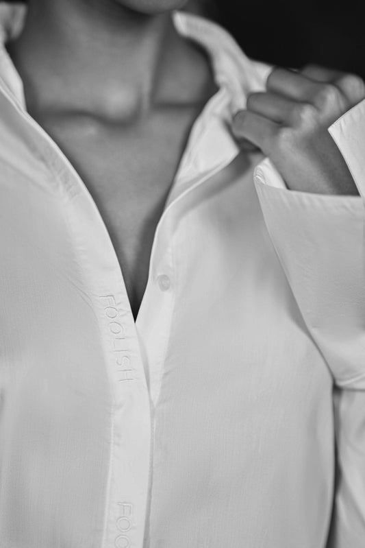 close up of branded detail on womens luxury white shirt
