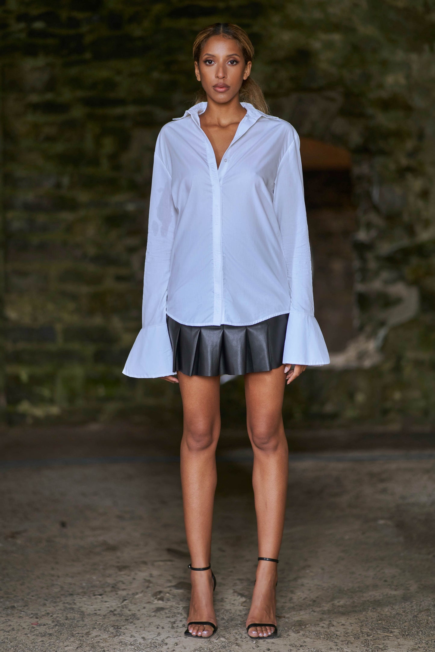model styled in luxury white shirt with leather skirt and heels