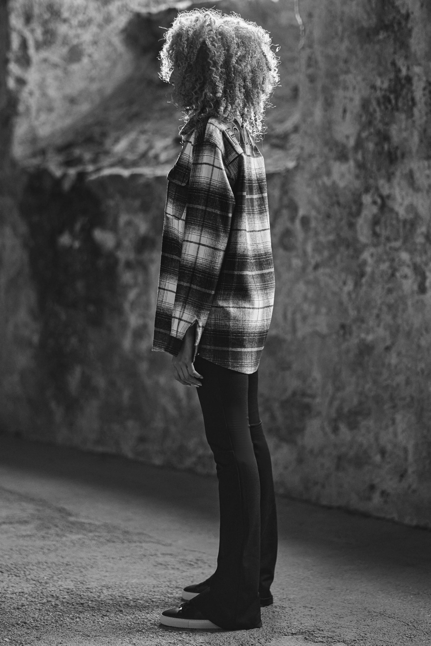 side view of model in luxury check shirt with black pants