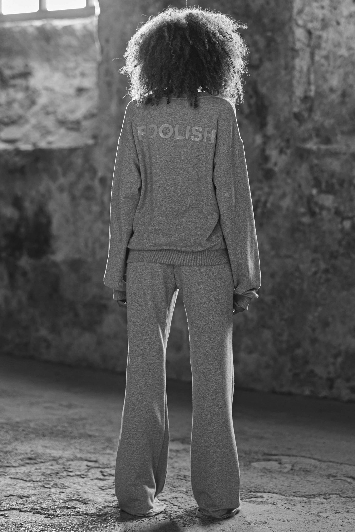 model wearing wide leg joggers and matching sweatshirt in grey