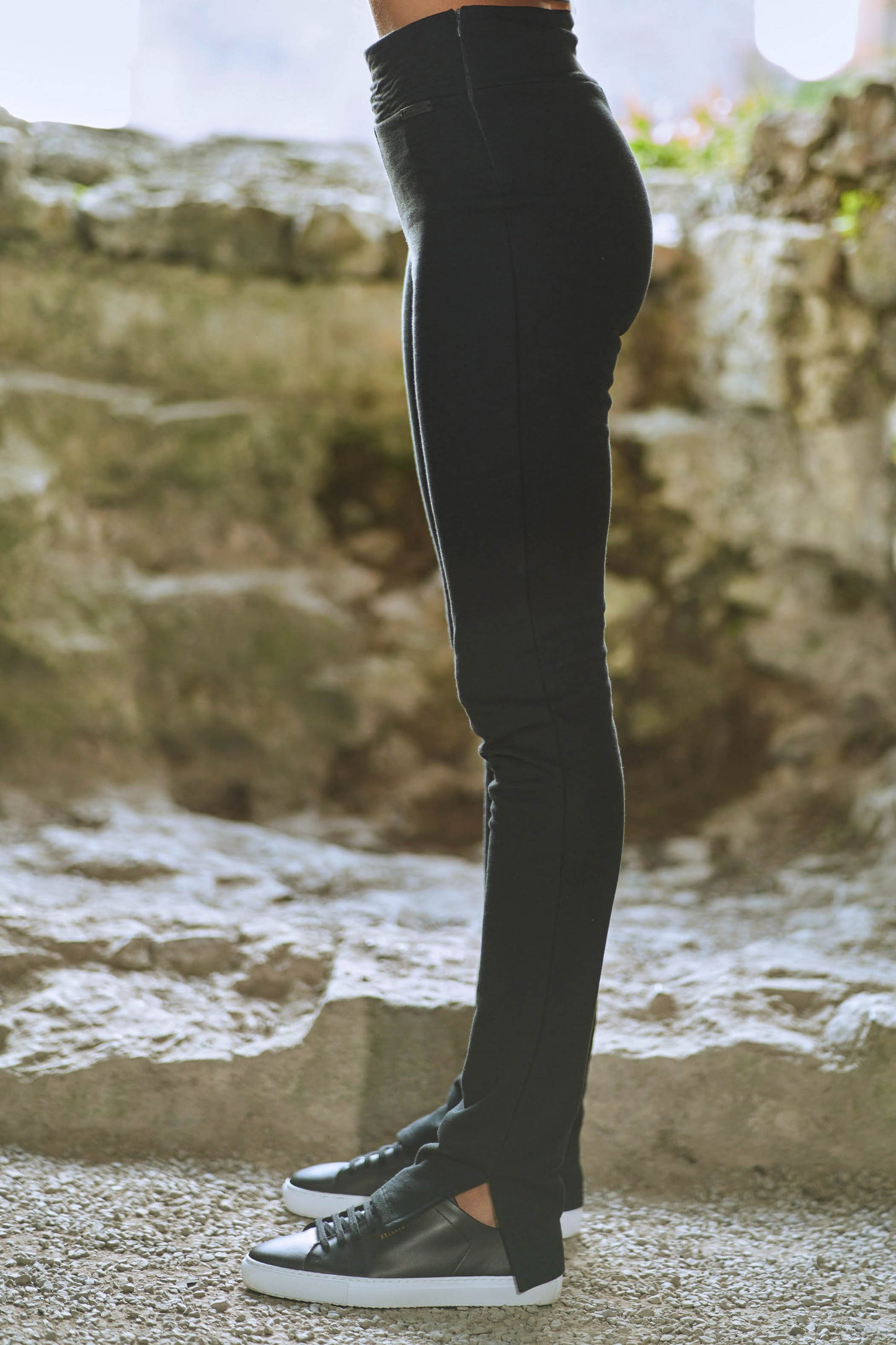 side view of model wearing womens black split hem pants