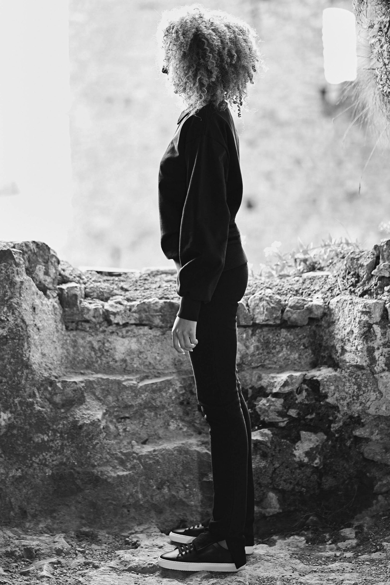 side profile shot of model wearing black luxury athleisure sweatshirt in black
