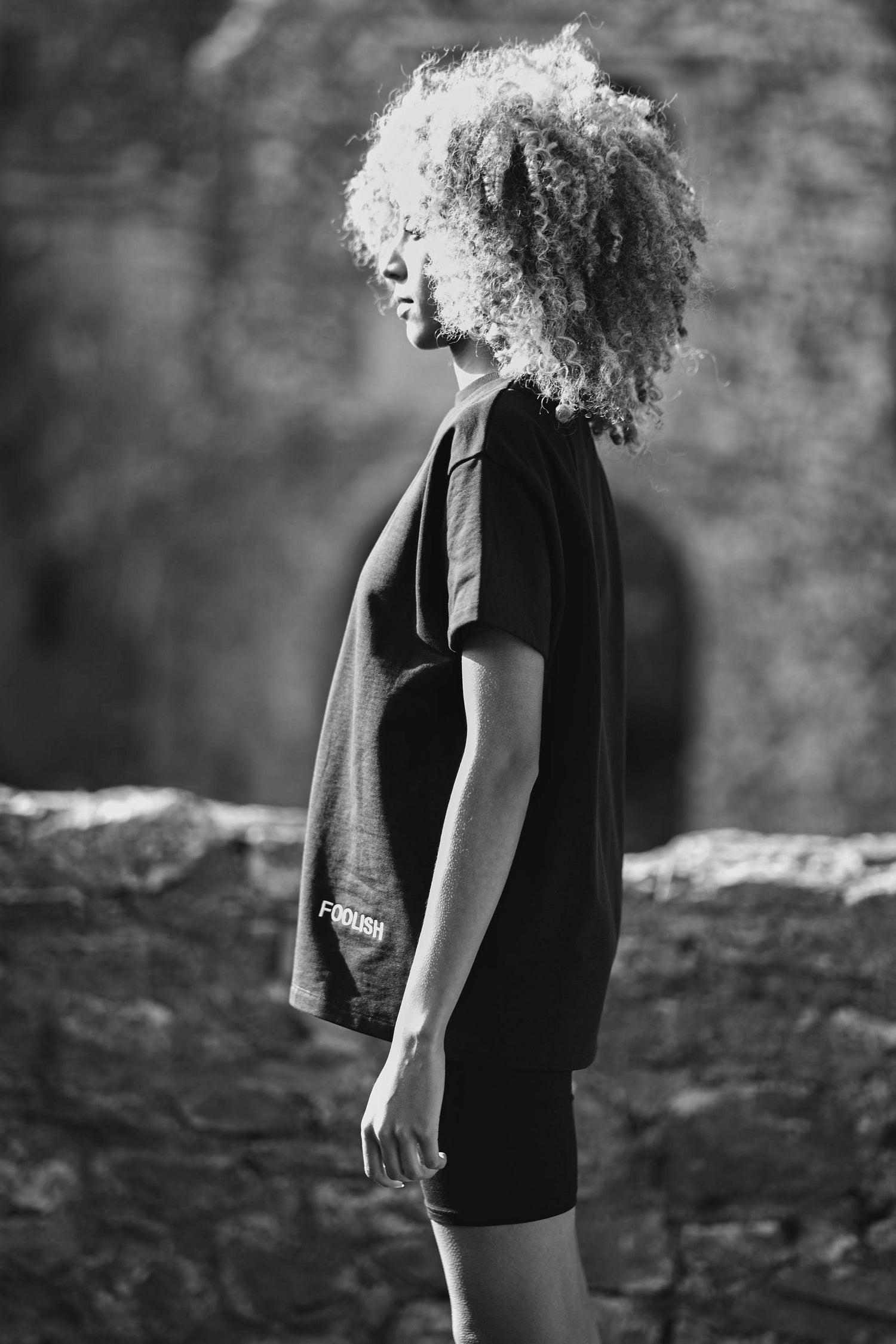 side view of model wearing organic womens black t-shirt and shorts