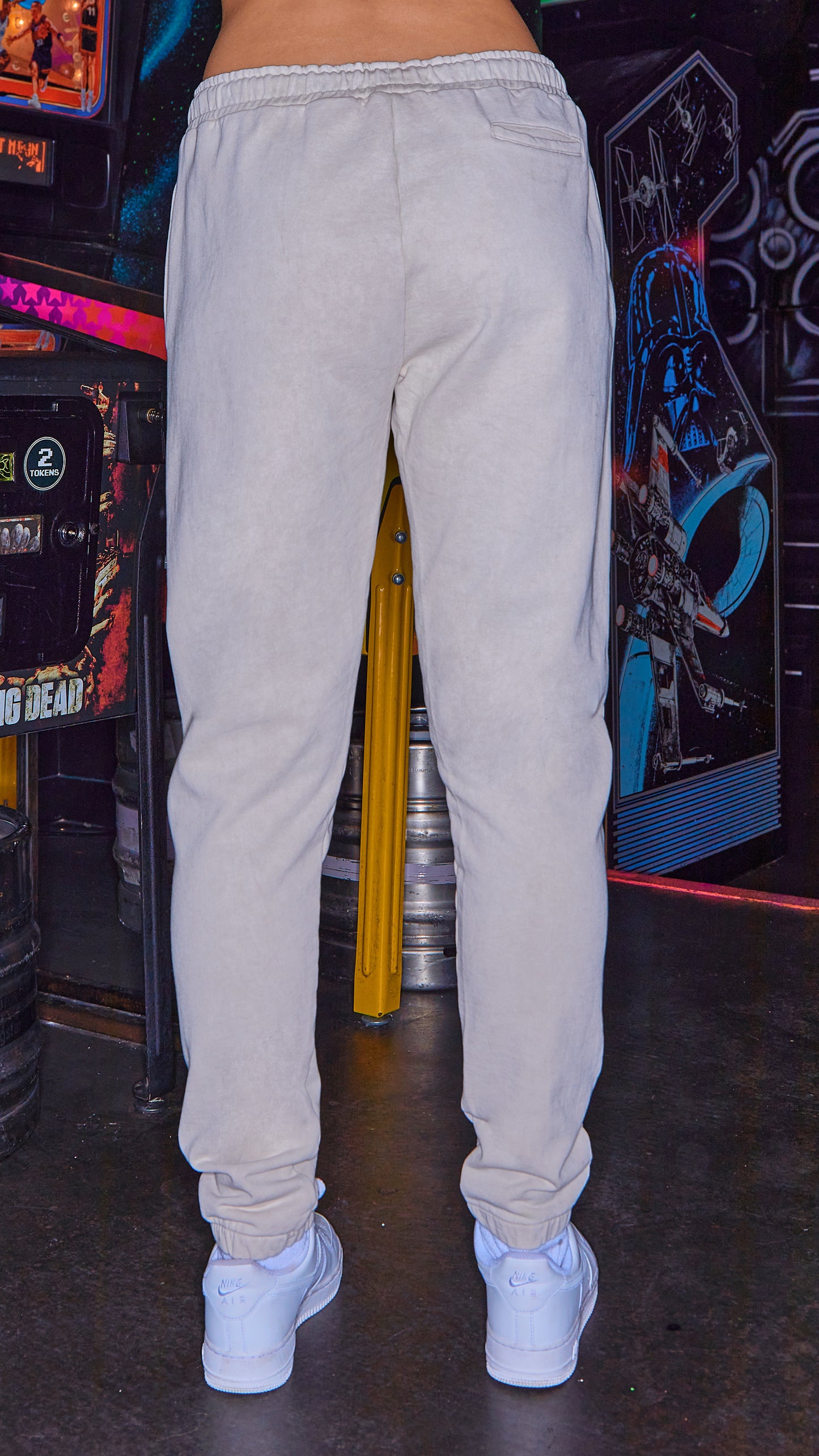 back view of model wearing womens joggers in stone with white trainers