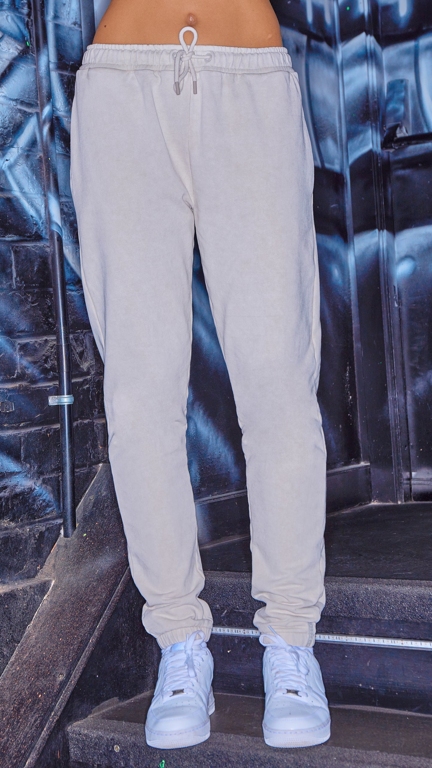 model wearing luxury womens joggers in stone with white trainers