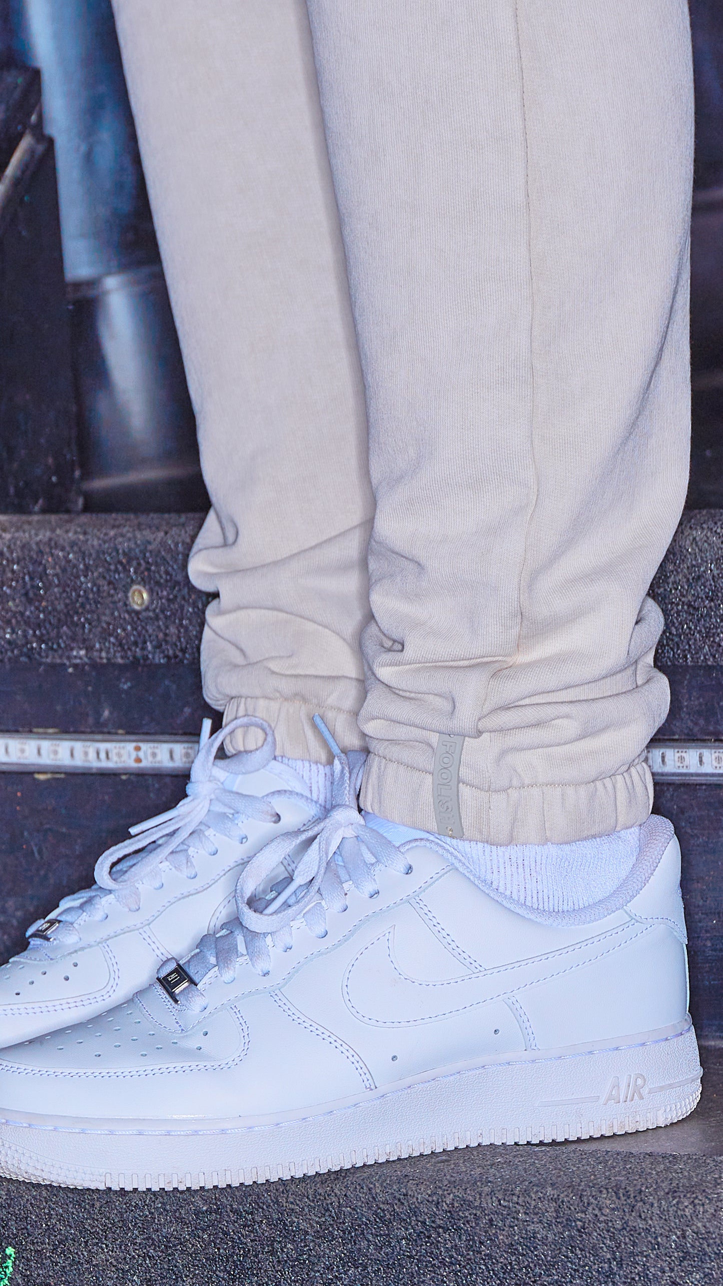 branded detail on cuff of womens luxury joggers in stone with white trainers