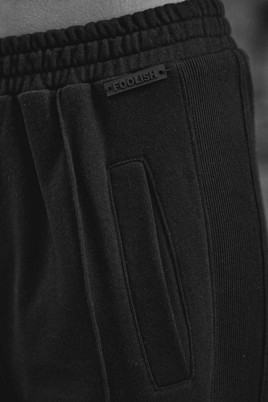 close up detail on luxury track joggers in black