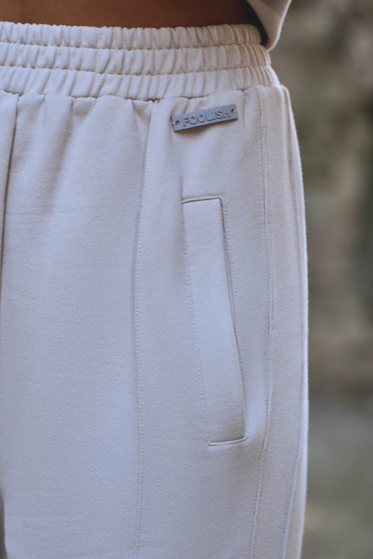 close up detail of womens cream luxury joggers