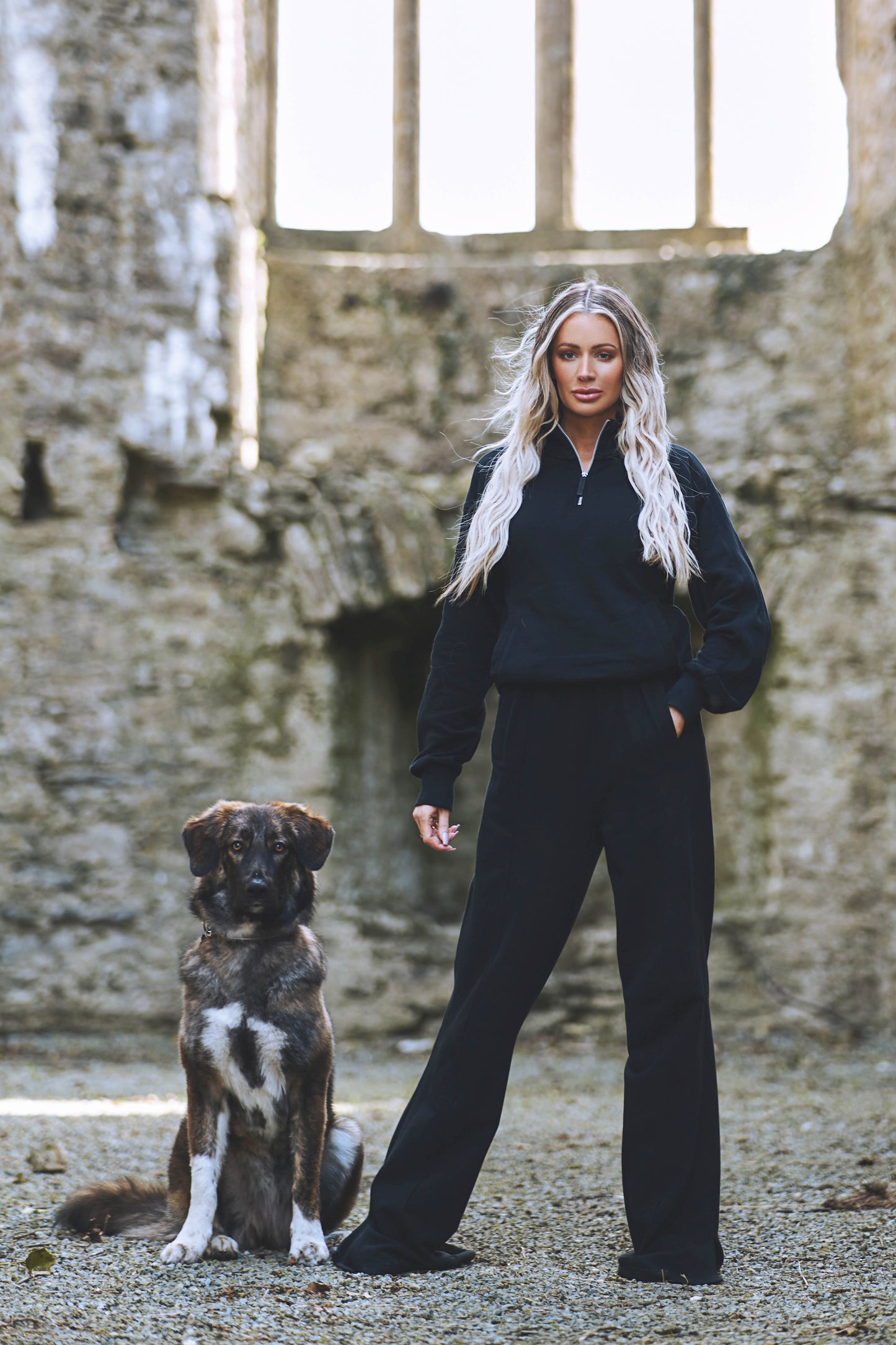 model wearing full womens luxury tracksuit in black posing with dog