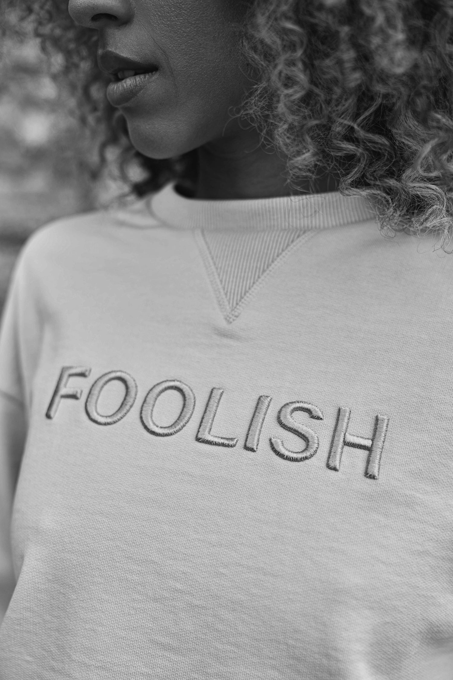black and white image of branded detail on luxury cream sweatshirt