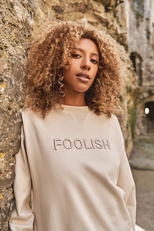 close up of branded detailing on womens luxury sweatshirt in cream