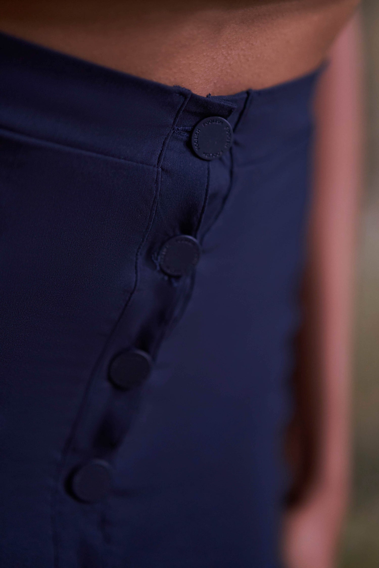 close up button detailing on womens luxury navy skirt