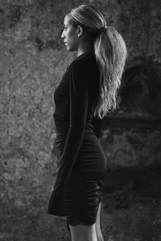 side view of model wearing portrait dress in black