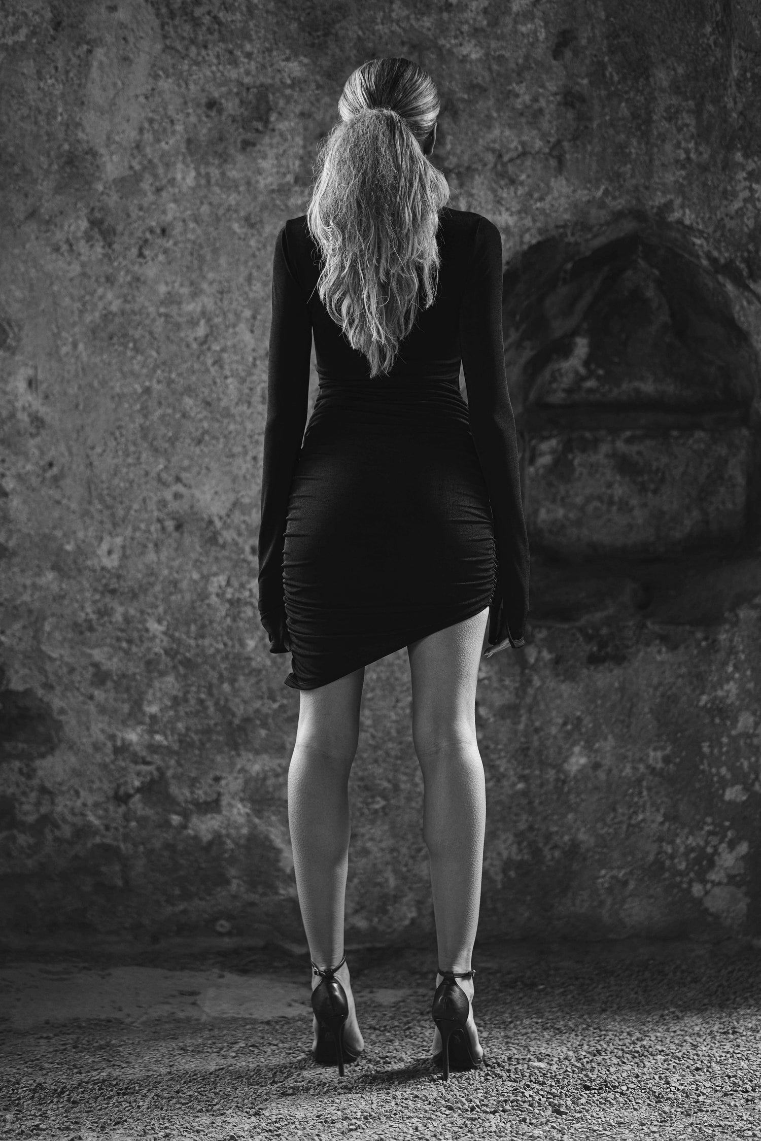 back view of model wearing asymmetrical womens black dress