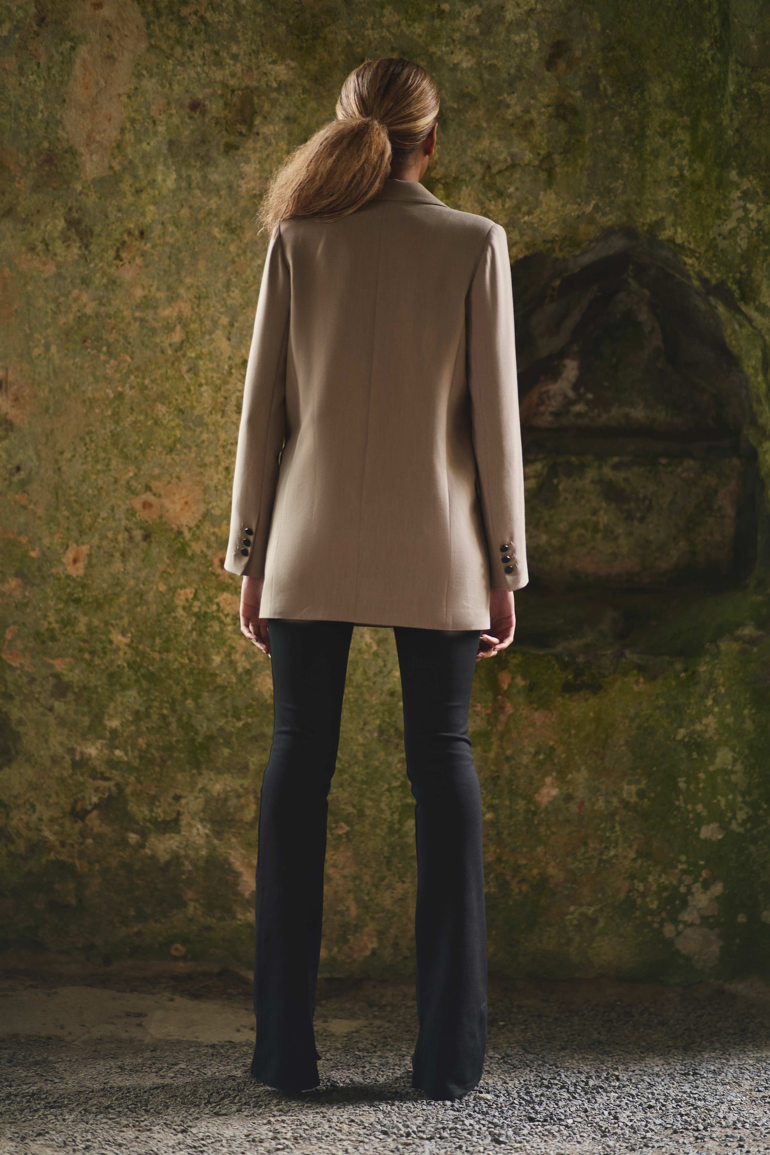 full back view of womens luxury blazer in camel styled with black pants
