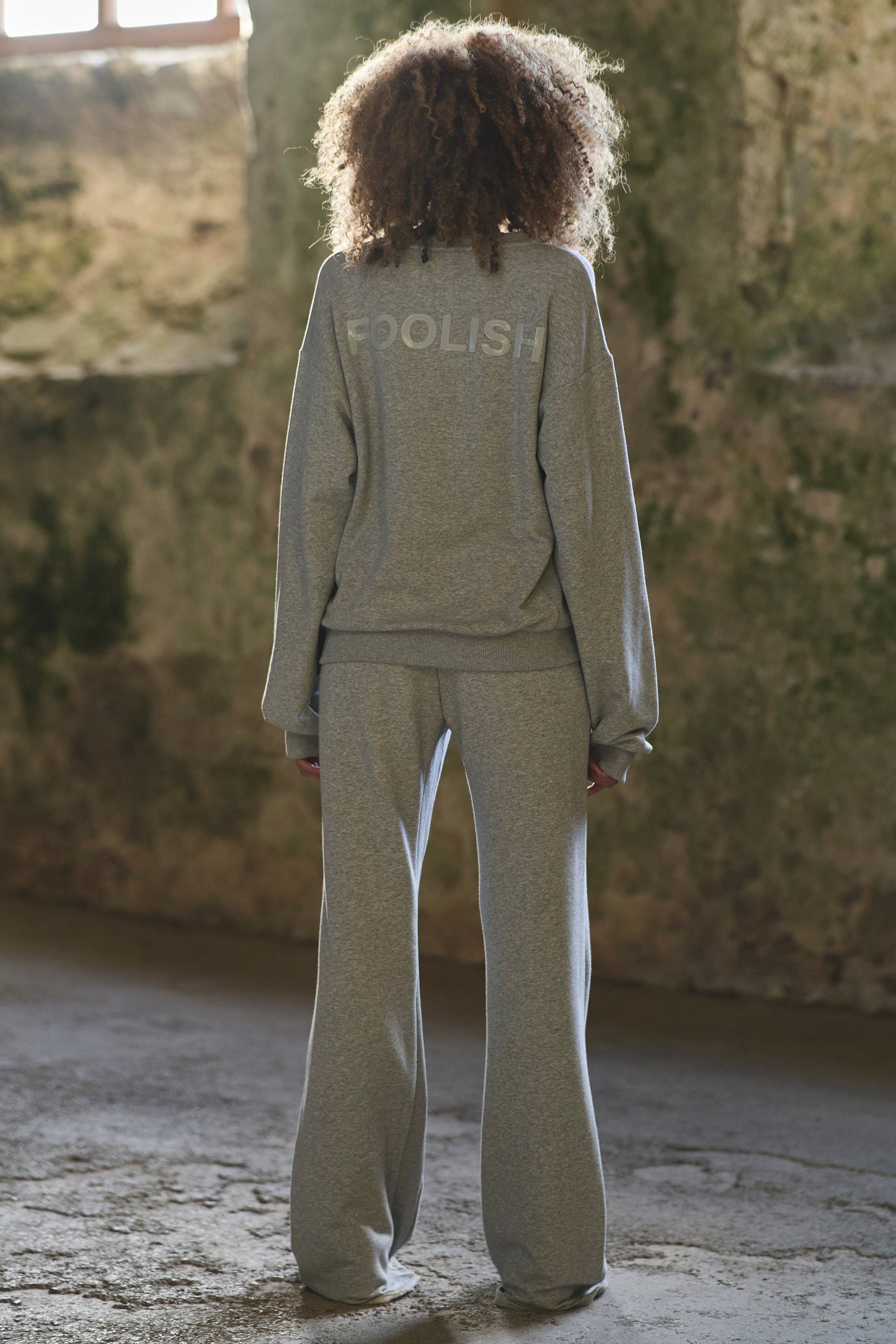 back image of model styled in grey luxury tracksuit 