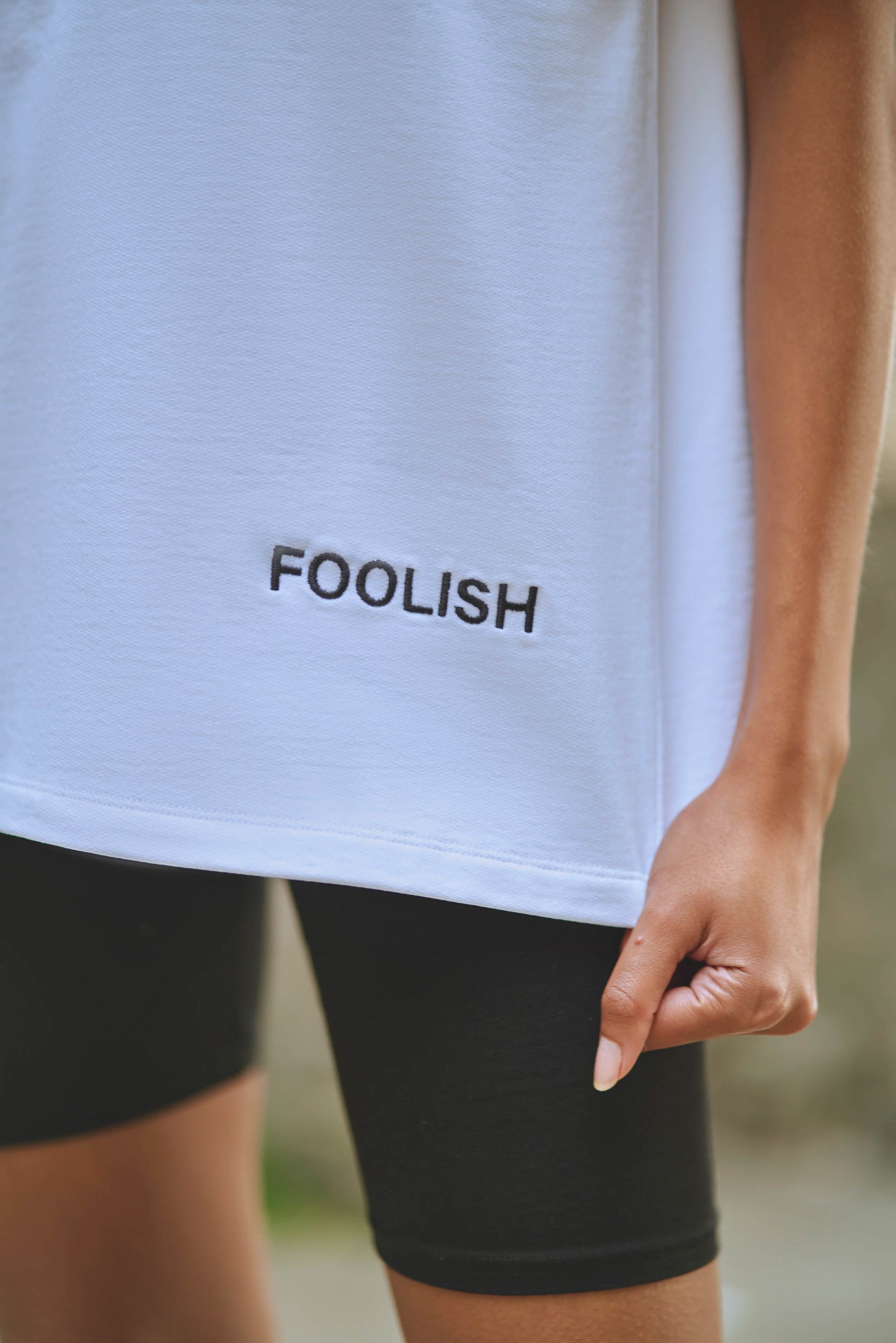 close up image of branded detailing on white oversized and organic t-shirt