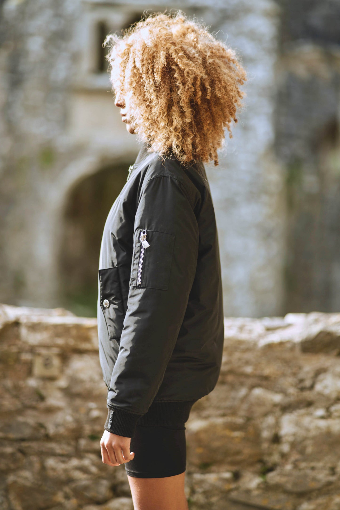 side view of womens contemporary bomber jacket in black