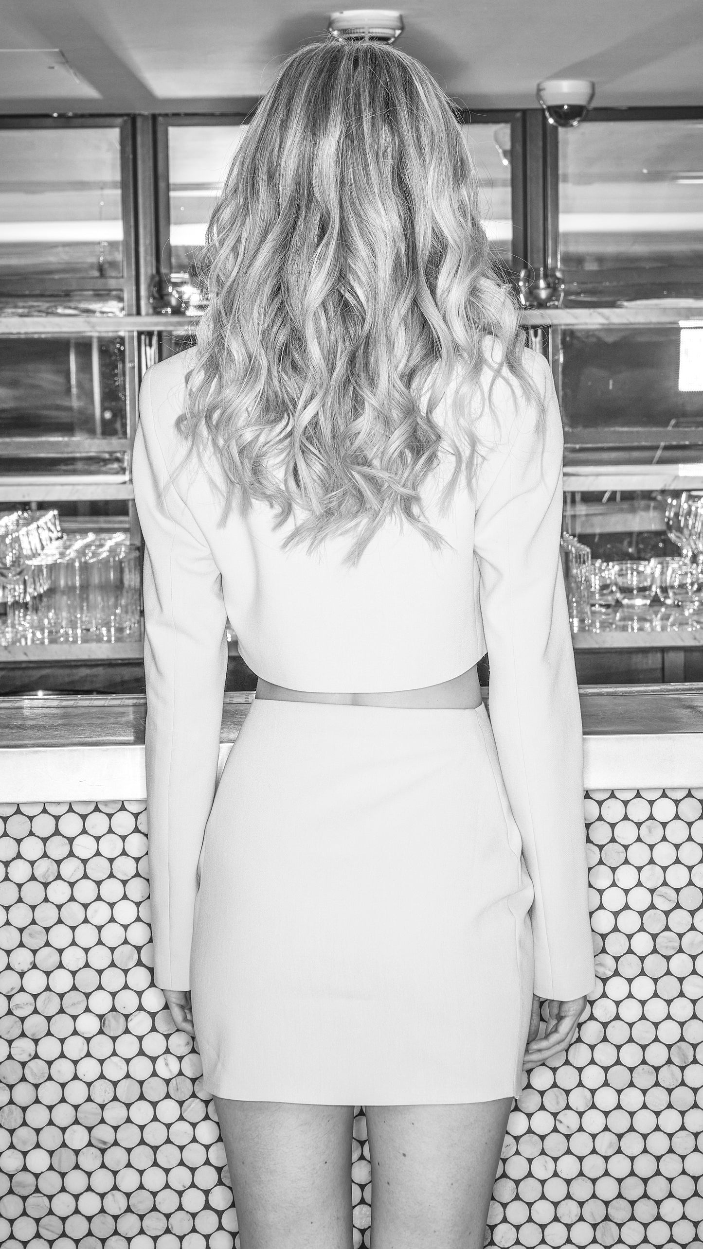 back view of cropped luxury blazer and skirt in black and white image