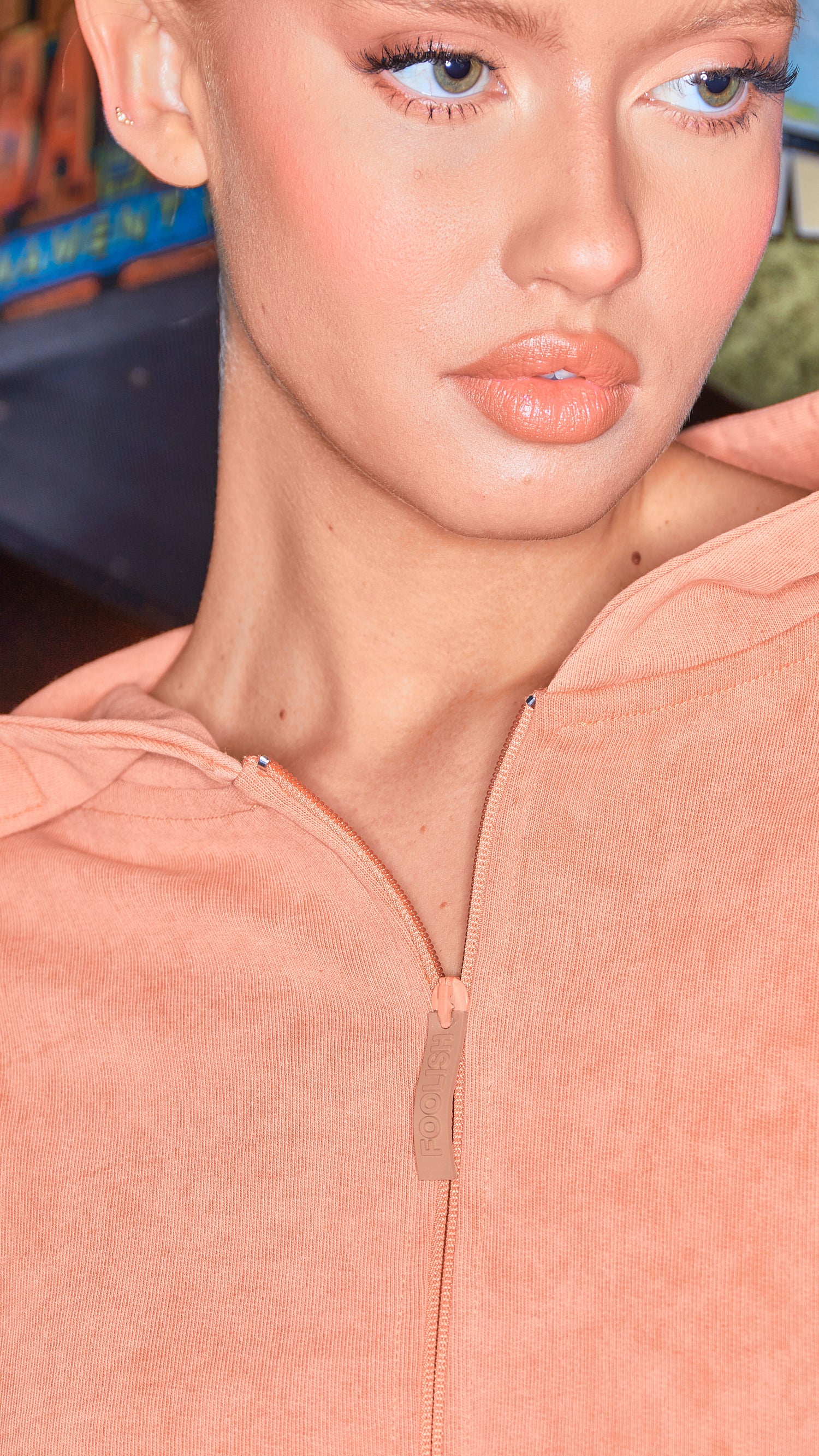 close up of zip detail on womens hoodie in burnt orange
