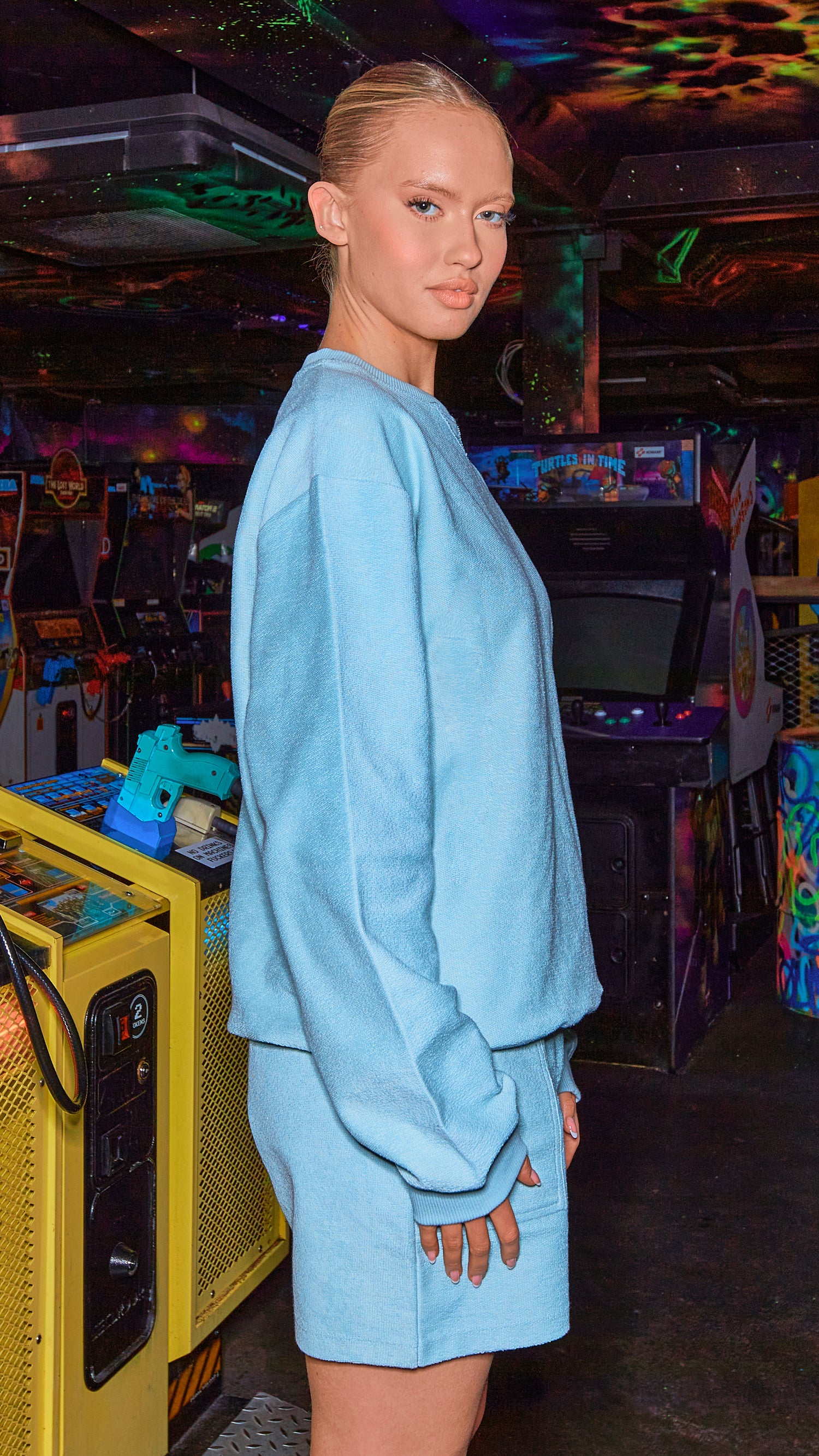 model posing to the side in chalk blue sweatshirt and shorts set